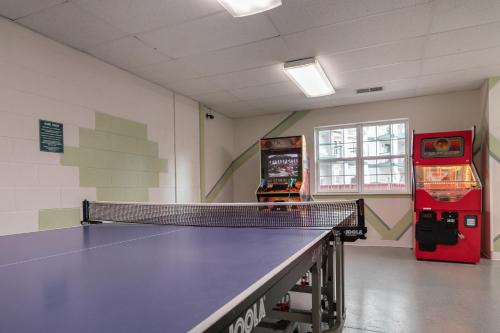 a room with a ping pong table and a soda machine at Carriage Place in Branson
