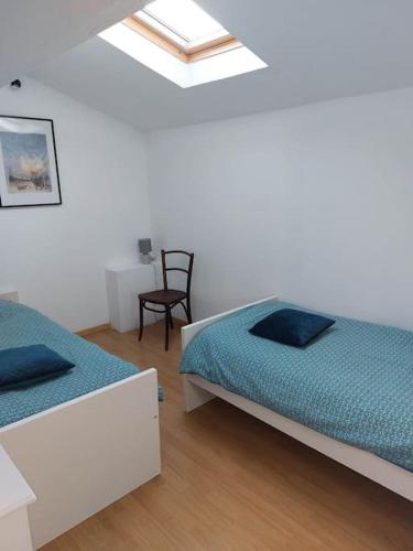 une chambre avec deux lits et une chaise dans l'établissement La Tour de Jeanne, à 10 minutes de Saint-Emilion, à Gardegan-et-Tourtirac