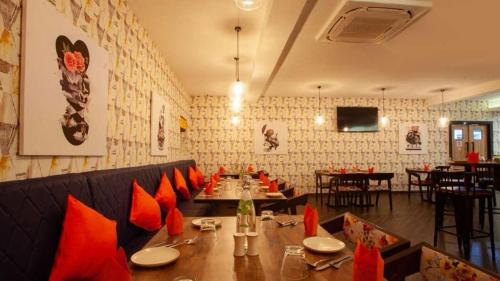 a dining room with a long table and red cushioned chairs at Hotel I-stay Hitec in Hyderabad