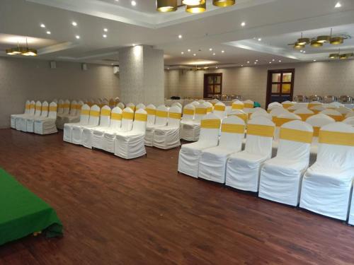 a room with rows of white and yellow chairs at Hotel I-stay Hitec in Hyderabad
