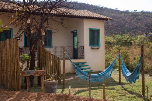 a house with a hammock in front of it at Pousada Lapinha Da Serra 1 - Chalés Independentes e Privativos - Liberdade e Conforto na natureza in Santana do Riacho