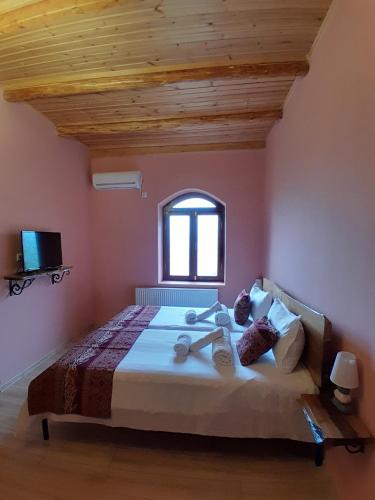 a bedroom with a large bed with a window at Château Fort de Manavi, Boutique Hotel in Manavi