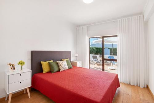 a bedroom with a red bed with a view of a patio at Apartment Zeza in Albufeira