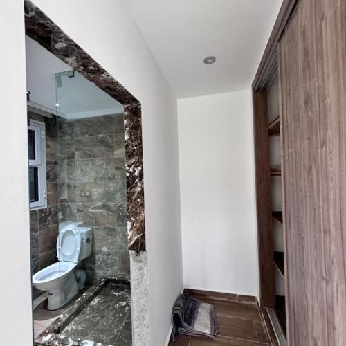 a bathroom with a toilet and a mirror at Villa de Vacances avec Piscine in Tangier
