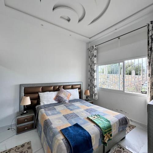 a bedroom with a large bed and a window at Villa de Vacances avec Piscine in Tangier