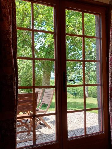 a window with a view of a rocking chair outside at Le Verger de Roiville in Roiville