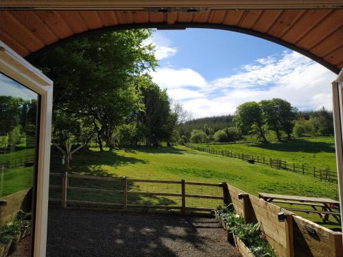 a view of a field from a barn doorway at little peru luxury pods and alpaca farm in Crosshill