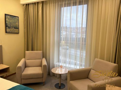 a hotel room with two chairs and a window at Hotel Siesta in Užice