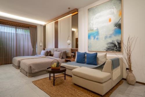 a hotel room with two beds and a couch at KammOra Living and Villas - Bali Invest Club in Canggu