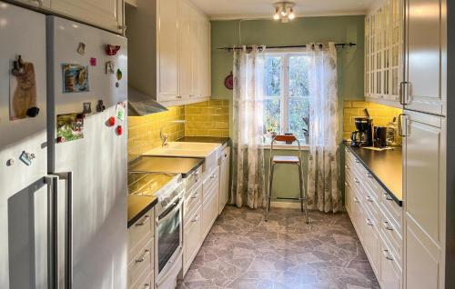a kitchen with a white refrigerator and a sink at Nice Home In Alsterbro With Sauna in Alsterbro
