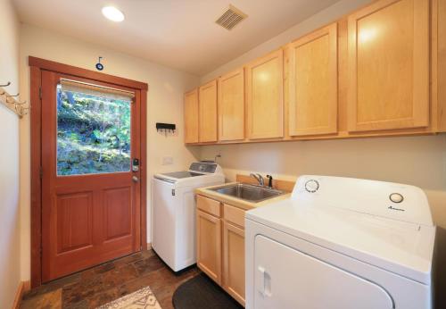 eine Küche mit Spüle, Waschmaschine und Trockner in der Unterkunft Sandbar Haven in Hood River