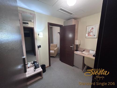 a hotel room with a desk and a room at Hotel Siesta in Užice