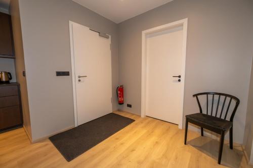 an empty room with a chair and two doors at Storigardur Premium Apartments in Húsavík