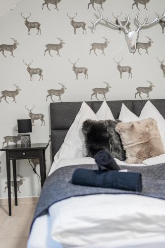 a bedroom with a bed with a deer stenciled wall at Innsbruck Underground Atelier in Innsbruck