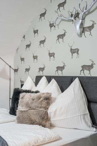 a bedroom with a bed with a wall with deer decals at Innsbruck Underground Atelier in Innsbruck
