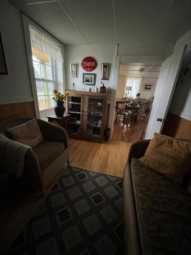 a living room with a couch and a dining room at Gite de la Baie Hatée in Bic