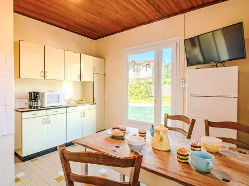 une cuisine avec une table en bois et des chaises ainsi qu'une salle à manger dans l'établissement Holiday Home Trait d'Union by Interhome, à Mimizan