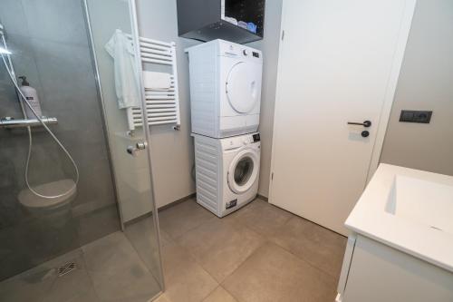 a bathroom with a washing machine and a washer at Storigardur Premium Apartments in Húsavík