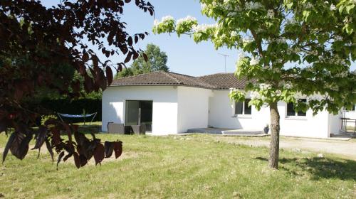 a white house with a tree in the yard at La Maison des Hirondelles, piscine, billard, ping pong, 3 terrasses et jardin in Montauban