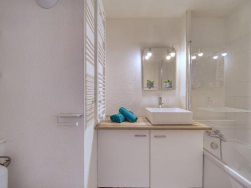 une salle de bain blanche avec un lavabo et une douche dans l'établissement Studio Soyouz Vanguard-104 by Interhome, au Corbier