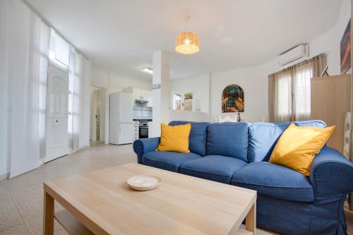 a living room with a blue couch and a table at Villa Brisa de Gairia in Antigua