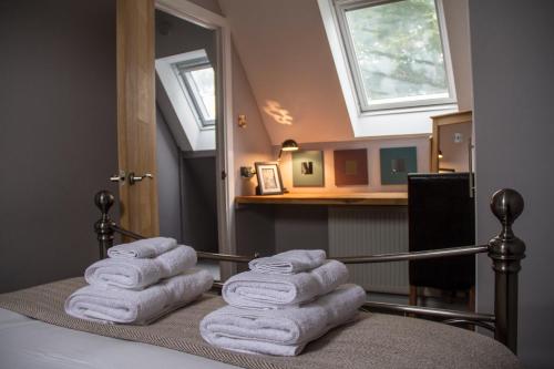 una pila de toallas sentadas encima de una cama en Home Farm Apartments en Portree