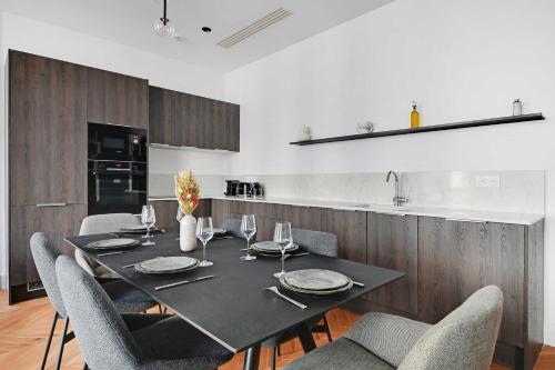 une salle à manger avec une table et des chaises noires dans l'établissement Welcoming apartment - 2BR-6P - Opera, à Paris