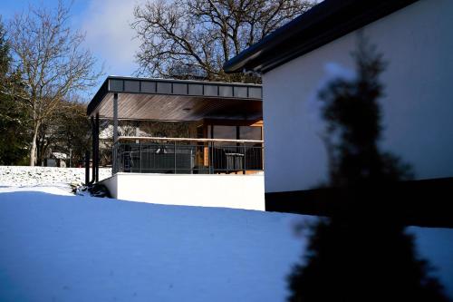a building with snow in front of it at Somos Lux Vendégház in Somoskőújfalu