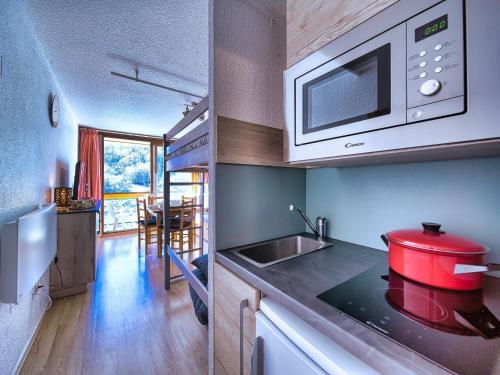 une cuisine avec une casserole rouge sur un comptoir dans l'établissement Studio Soyouz Vanguard-102 by Interhome, au Corbier