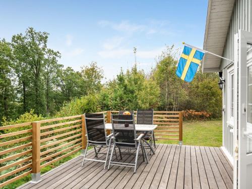 a deck with a table and chairs and a flag at Holiday Home Gaslunda Tvåan by Interhome in Olofström
