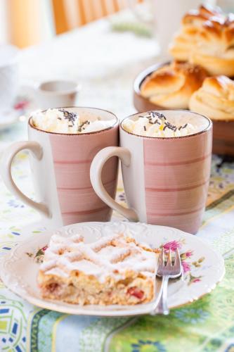 a table with two cups of coffee and a plate of food at Marga`s Ferienwohnung in Lembach im Mühlkreis