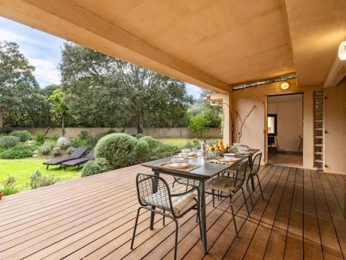 une terrasse en bois avec une table et des chaises dessus dans l'établissement Holiday Home Villa Les Chênes by Interhome, à Porto-Vecchio