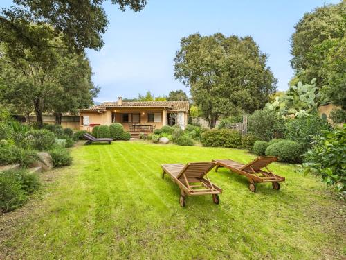 une cour avec deux bancs et une maison dans l'établissement Holiday Home Villa Les Chênes by Interhome, à Porto-Vecchio