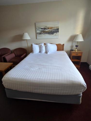 a large white bed in a hotel room at Travelodge by Wyndham Port Elgin in Port Elgin