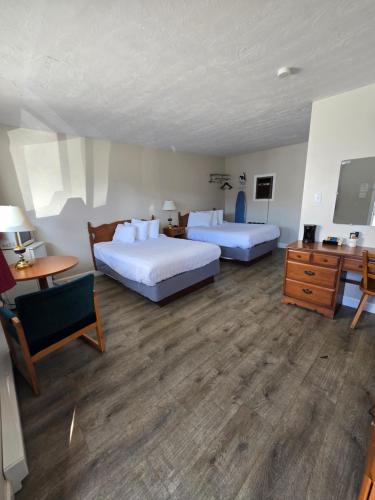 a hotel room with two beds and a desk at Travelodge by Wyndham Port Elgin in Port Elgin
