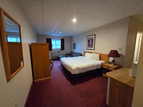 a hotel room with a bed and a couch at Travelodge by Wyndham Port Elgin in Port Elgin