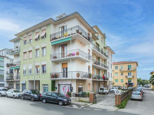 a tall building with cars parked in front of it at Apartment Artista by Interhome in Cecina