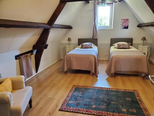 - 2 lits dans une chambre avec un canapé et un tapis dans l'établissement Maison climatisée avec jacuzzi à 10 min de Sarlat, à Sarlat-la-Canéda
