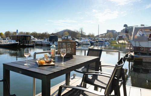 una mesa con dos copas de vino en un muelle con barcos en House Boat Tenerife, en Maastricht