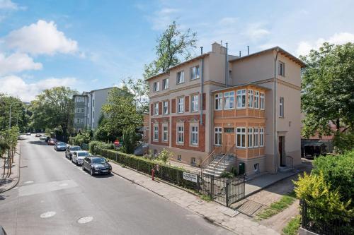 a building with cars parked on the side of a street at NEMO Deluxe - 3 min od plaży i parking by Lion Apartments Sopot in Sopot