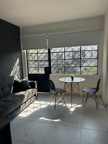 a living room with a couch and a table at Vidrio Suites Col Americana in Guadalajara