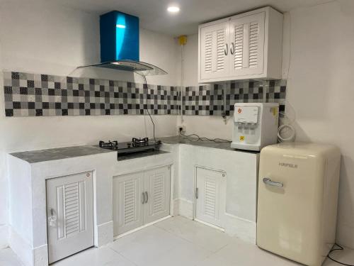 a kitchen with white cabinets and a refrigerator at Lucky Home Pool Villa Chiang Mai in Chiang Mai