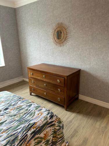 une chambre avec une commode et un miroir au mur dans l'établissement Gîtes à Gavray, à Gavray