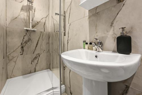 a bathroom with a sink and a shower at Cozy Sunlit Studio with Kitchenette in London