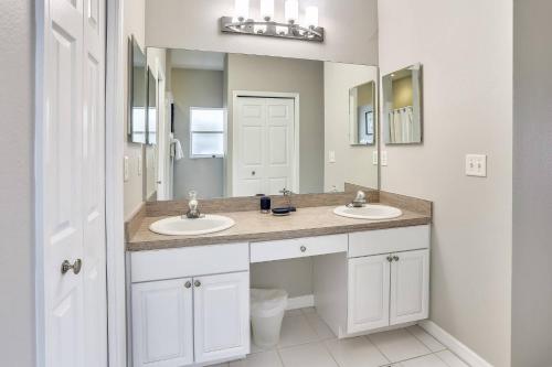 Un baño con dos lavabos y un espejo grande. en Spacious Beach Condo - Mariners Pointe, en Clearwater Beach