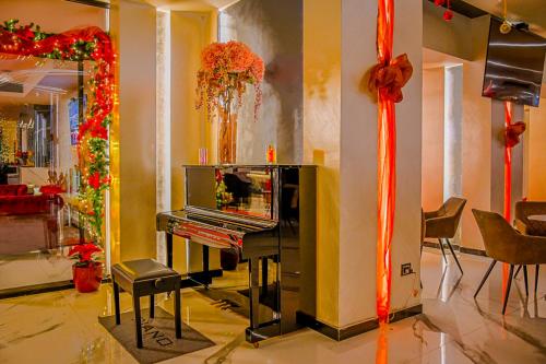 a room with a piano and christmas decorations at Hotel Vivas in Durrës