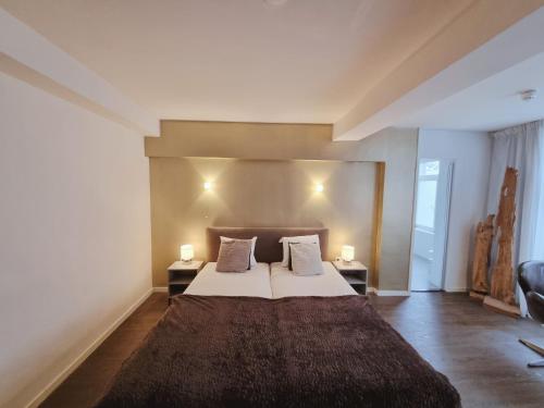 a bedroom with a large bed with two lamps at Saillant Hotel Maastricht City Centre - Auping Hotel Partner in Maastricht