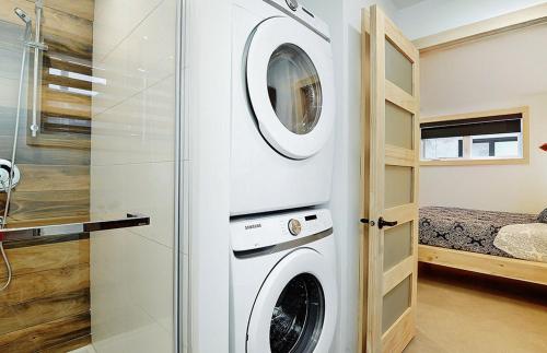 a washer and dryer in a bathroom with a bedroom at 102 chemin des Ruisselets in Stoneham