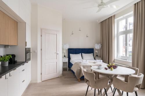 a white and blue bedroom with a table and a bed at NEMO Deluxe - 3 min od plaży i parking by Lion Apartments Sopot in Sopot
