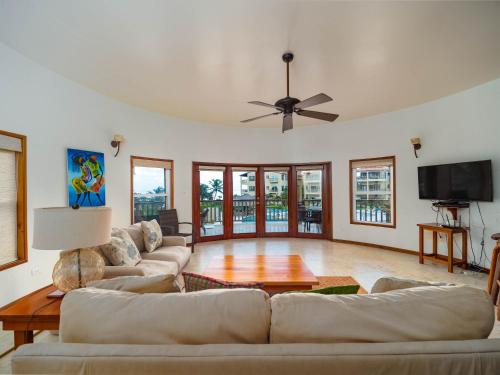 a living room with couches and a ceiling fan at Residences at Barrier Reef 8B Oceanview 2 BR by Stay Floreo in San Pedro